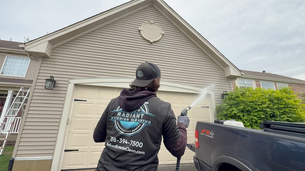 Radiant Exterior Cleaning soft washing vinyl siding on a home, professional pressure washing equipment